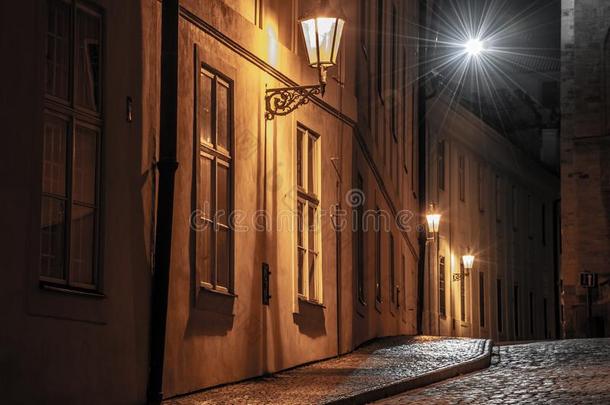 狭隘的铺鹅卵石的大街被照明的在旁边大街灯关于老的城镇,英语字母表的第16个字母