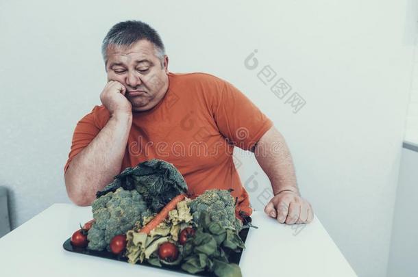 肥的<strong>打翻</strong>男人和盘子和素食者食物.