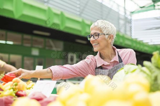 较高的女人卖蔬菜向交易