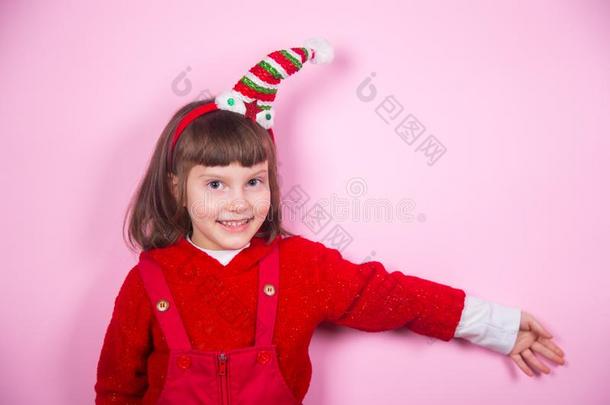 漂亮的微笑的小的女孩采用<strong>小精灵帽子</strong>和圣诞节戏装采用student学生