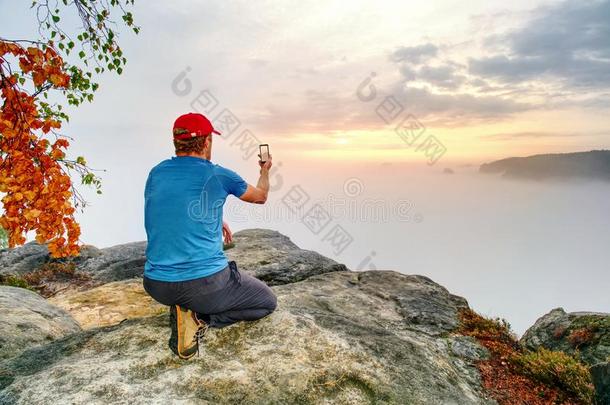 远足者拿自拍照照片,落下自然冒险活动.男人坐向st向