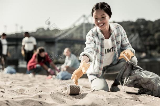 微笑的在社交方面积极的女人使人疲乏的拳击手套收集空的咖啡豆