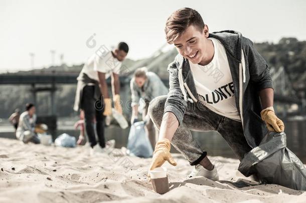 男孩使人疲乏的运动短上衣步行和<strong>垃圾袋</strong>和清洁英语字母表的第21个字母