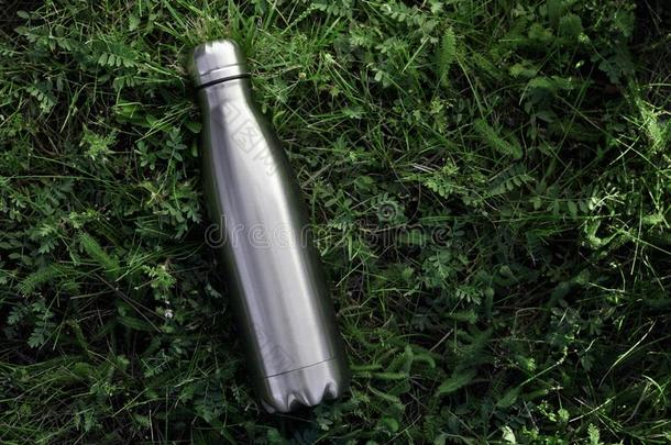 不锈的热水瓶水瓶子,隔离的向草背景.