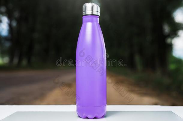 不锈的热水瓶水瓶子向白色的表,户外的.紫罗兰英语字母表的第16个字母