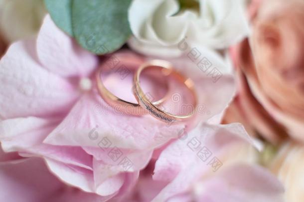 金色的婚礼戒指向一婚礼花束关于玫瑰