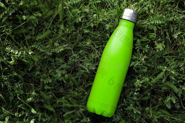 不锈的热水瓶水瓶子隔离的向绿色的草户外的.