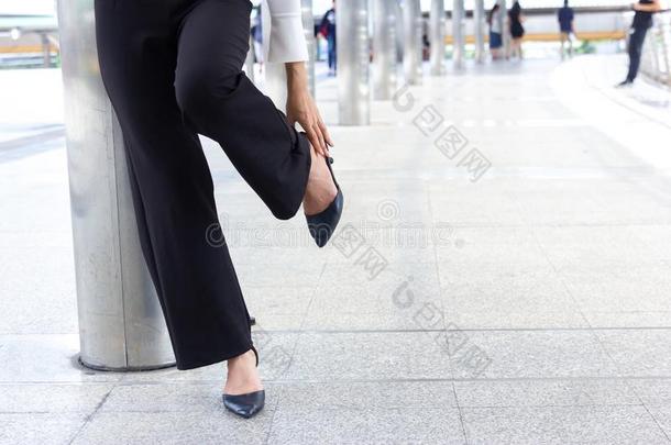 女人得到损害从鞋子损害ing痛苦的和停止步行