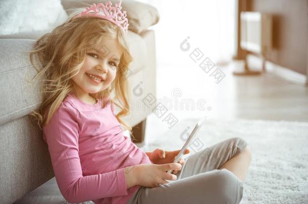 兴奋的小的女孩使用现代的科技和高兴