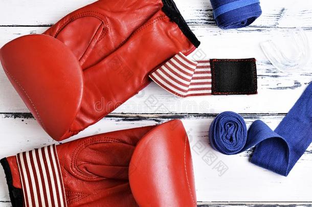 一副关于皮红色的拳击拳击手套,蓝色绷带