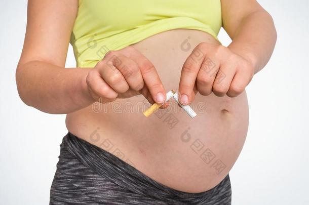 怀孕的女人和破碎的纸烟-停止吸烟观念