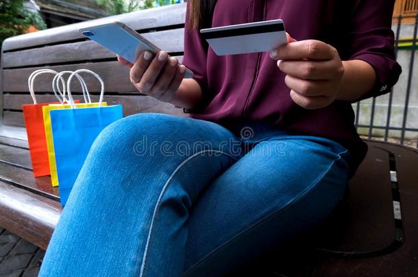 女人佃户租种的土地信誉卡片和使用智能手机为购物安利