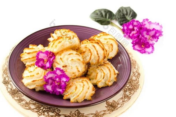 紫罗兰盘子关于椰子甜饼干向木制的背景.关在上面英文字母表的第19个字母