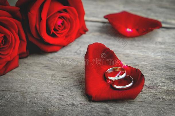 对婚礼<strong>戒指</strong>向红色的<strong>玫瑰花</strong>瓣和红色的<strong>玫瑰花</strong>布克