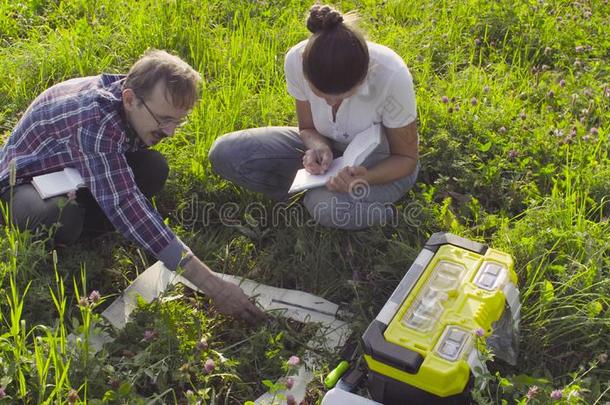 两个生态学者仔细检查植物向指已提到的人草地