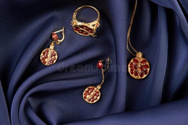 红宝石戒指,项链和ear戒指s向蓝色丝背景和