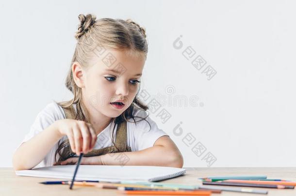 值得崇拜的小的女学生绘画和颜色铅笔