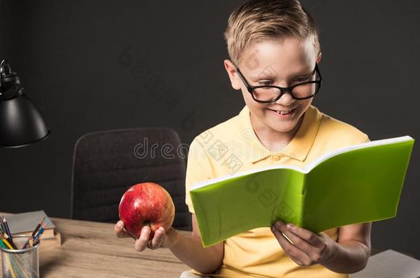 微笑的<strong>男生</strong>采用<strong>眼镜</strong>hold采用g苹果和do采用g家庭作业