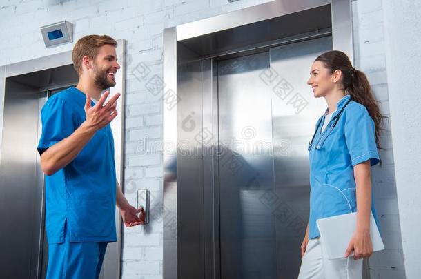 医学的学生讲话在期间等候电梯