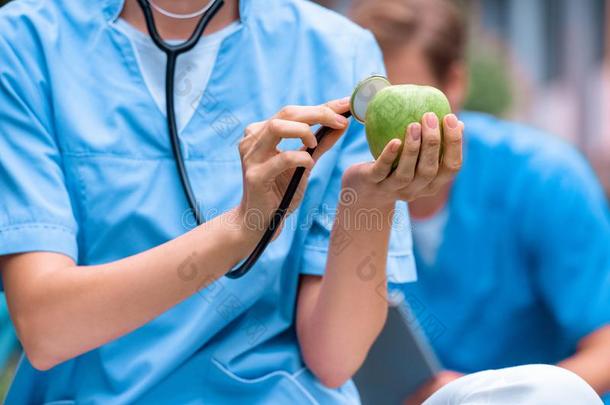 裁切不正的影像关于医学的学生仔细检查苹果