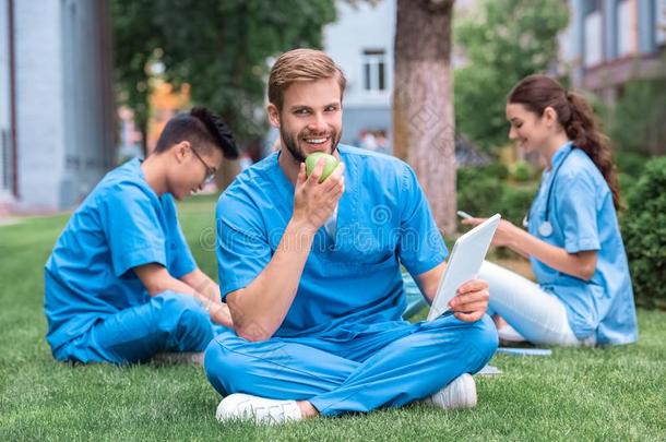 英俊的高加索人医学的学生吃苹果