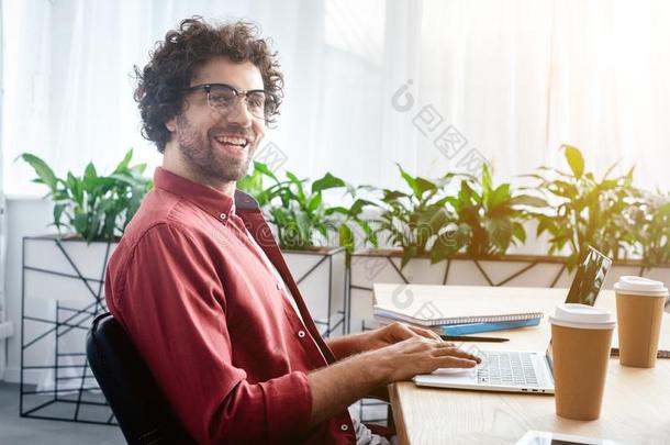 英俊的年幼的男人采用眼镜us采用g便携式电脑和smil采用g在凸轮