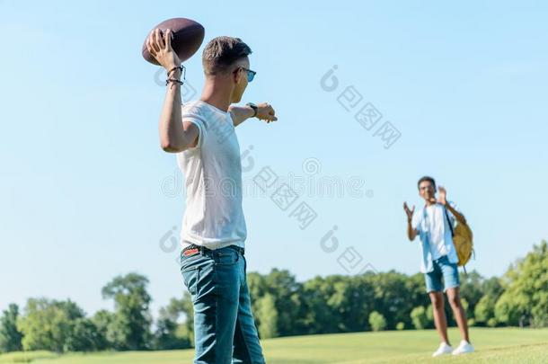 供多种族用的十几岁的男孩演奏和橄榄球运动球