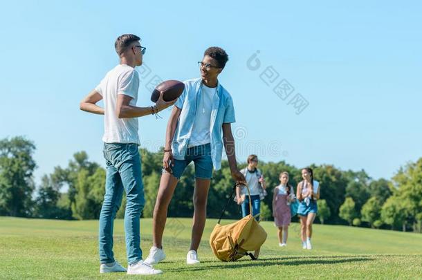 供多种族用的男孩演奏和橄榄球运动球在期间同学人名