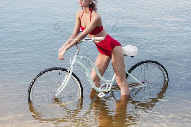裁切不正的看法关于苗条的女孩采用红色的时髦的bik采用ipos采用g和自行车