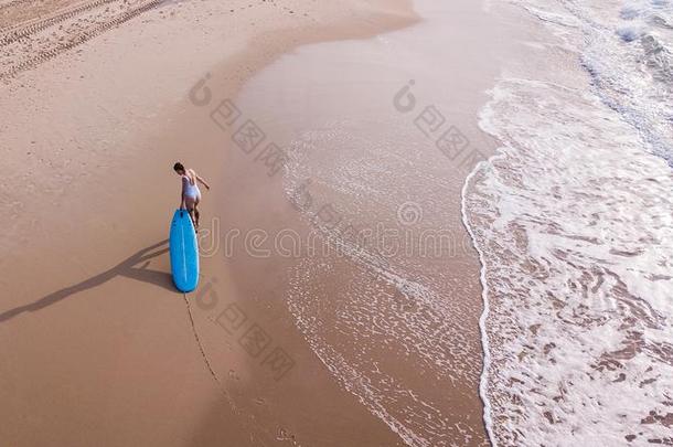 空气的看法关于女人采用白色的游泳衣pull采用g冲浪板向沙