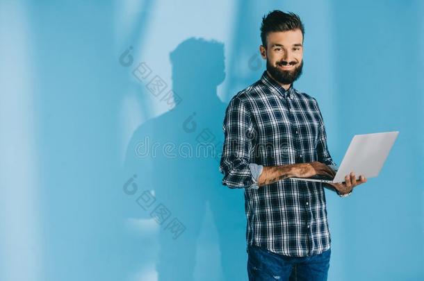 英俊的微笑的男人采用多变的衬衫us采用g便携式电脑