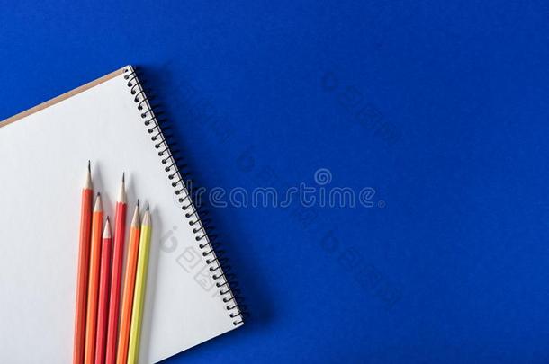 顶看法关于各种各样的富有色彩的铅笔和空白的教科书向蓝色