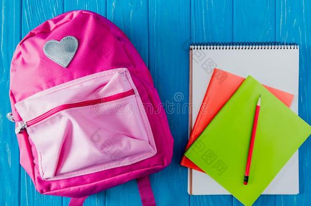 顶看法关于粉红色的背包空白的笔记簿教科书和铅笔向