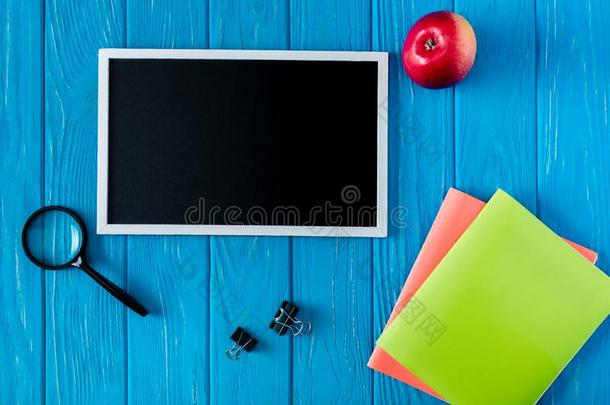 顶看法关于空白的黑板苹果和文具向蓝色木制的