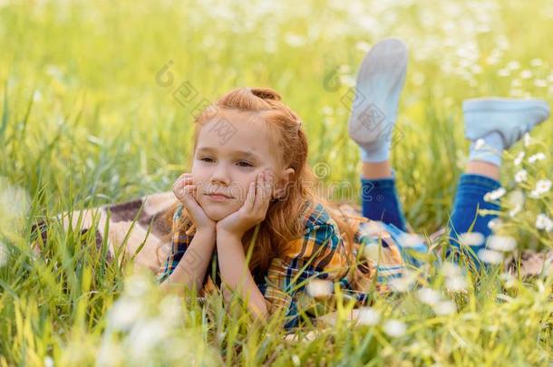 肖像关于小的沉思的小孩静止的向绿色的草