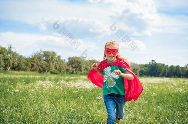 幸福的小孩采用红色的超级英雄斗篷和面具runn采用g采用草地