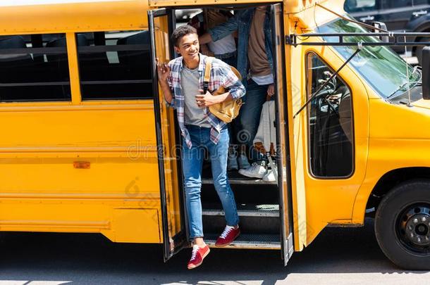 非洲的美国人青少年男生步行出局关于学校公共汽车