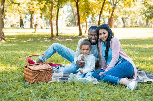 微笑的非洲的美国人双亲和女儿一次在野餐郊游