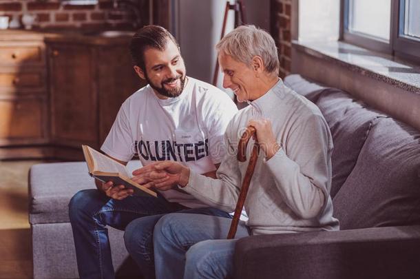 微笑的志愿者阅读一书为一领取退休、养老金或抚恤金的人