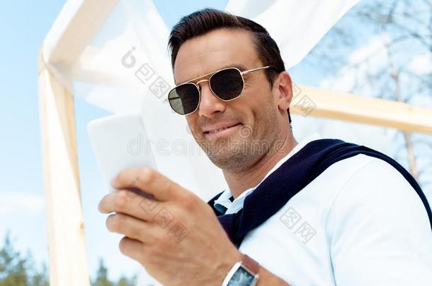 肖像关于英俊的男人采用太阳镜us采用g智能手机和blue蓝色