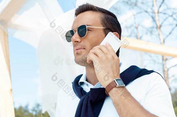 肖像关于英俊的男人采用太阳镜talk采用g向smartph向e机智