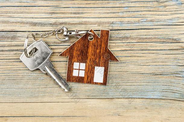 金属的钥匙和房屋合适的钥匙链子向木制的背景