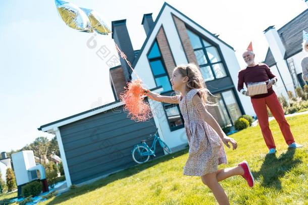 欢乐的女孩跑步和她节日的气球