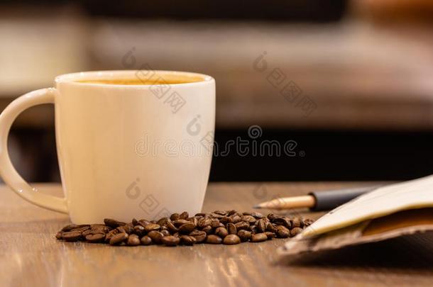 咖啡豆奶采用一杯子和咖啡豆be一n向木制的t一ble采用咖啡豆