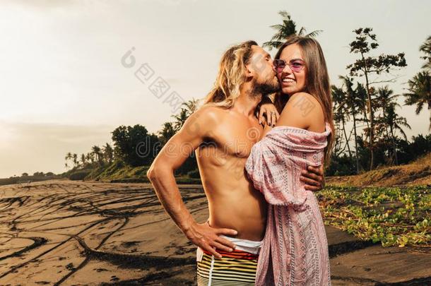英俊的男朋友接吻的女朋友向海滩