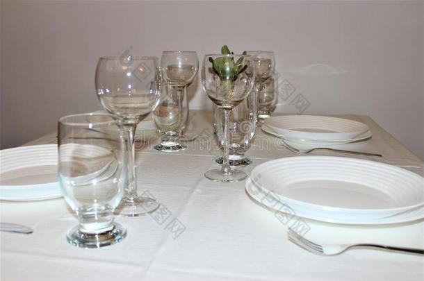 白色的盘子,眼镜,餐具向一白色的t一blecloth.