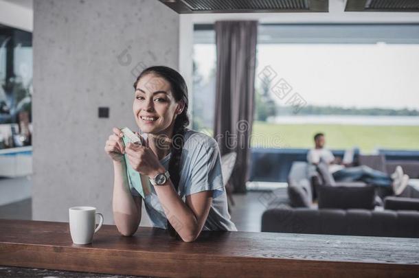 幸福的女人和书有样子的在照相机在桌面和咖啡豆