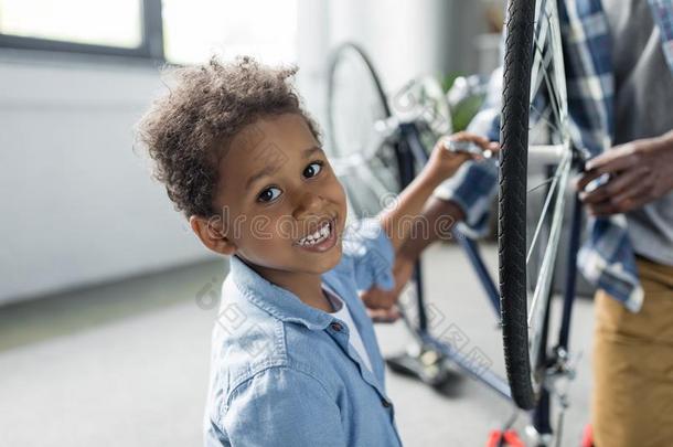值得崇拜的微笑的非洲的-美国人男孩纠正自行车