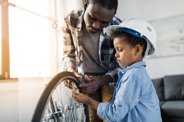 非洲的-美国人父亲和小的儿子采用建筑工人