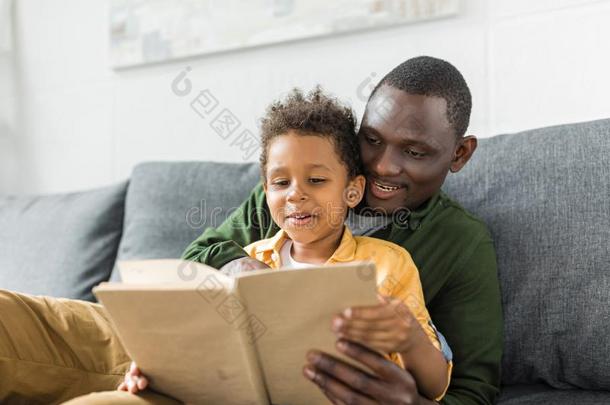 微笑的非洲的-美国人父亲和儿子阅读